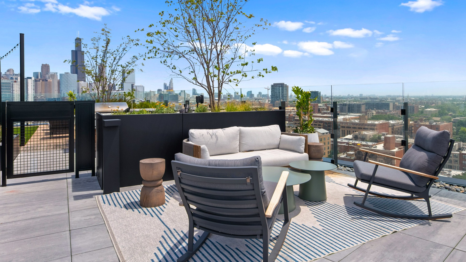 Serene rooftop seating area at Parq Fulton in Chicago, featuring comfortable lounge furniture, a rug, and stunning city views