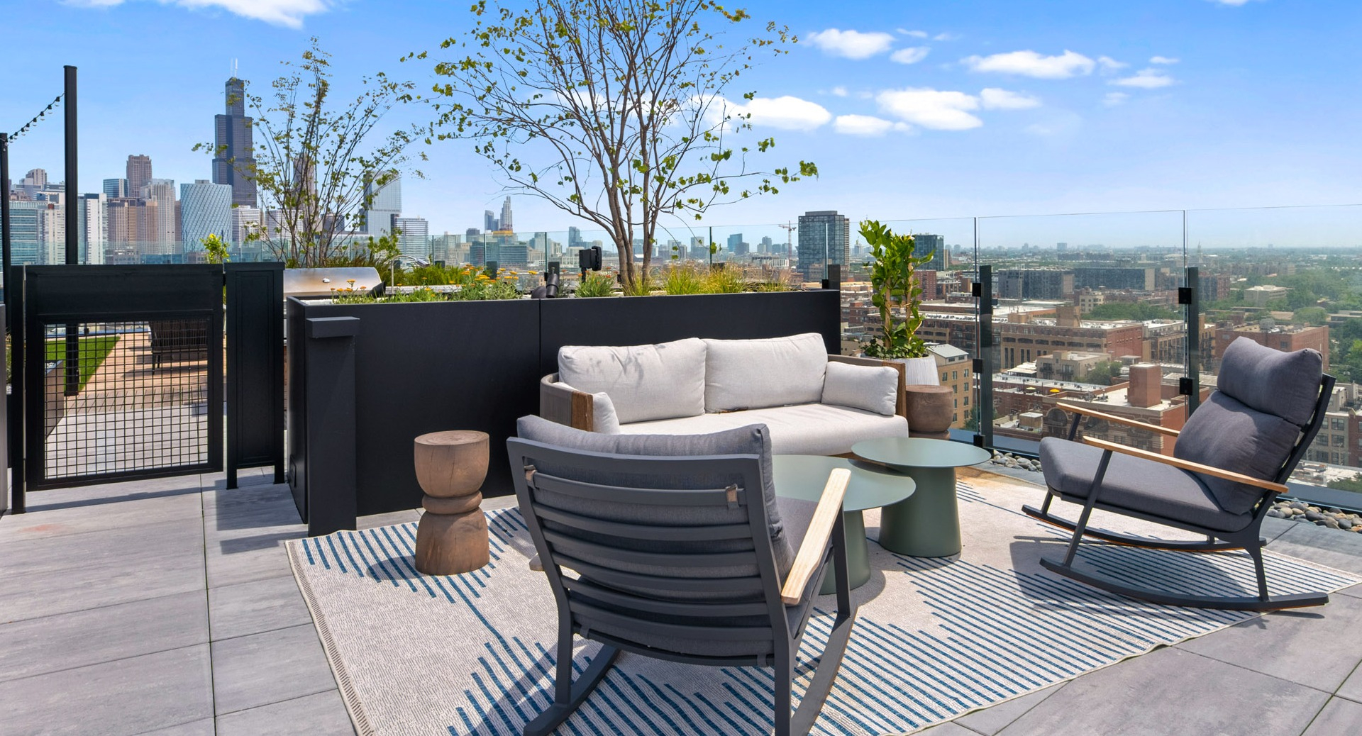Serene rooftop seating area at Parq Fulton in Chicago, featuring comfortable lounge furniture, a rug, and stunning city views