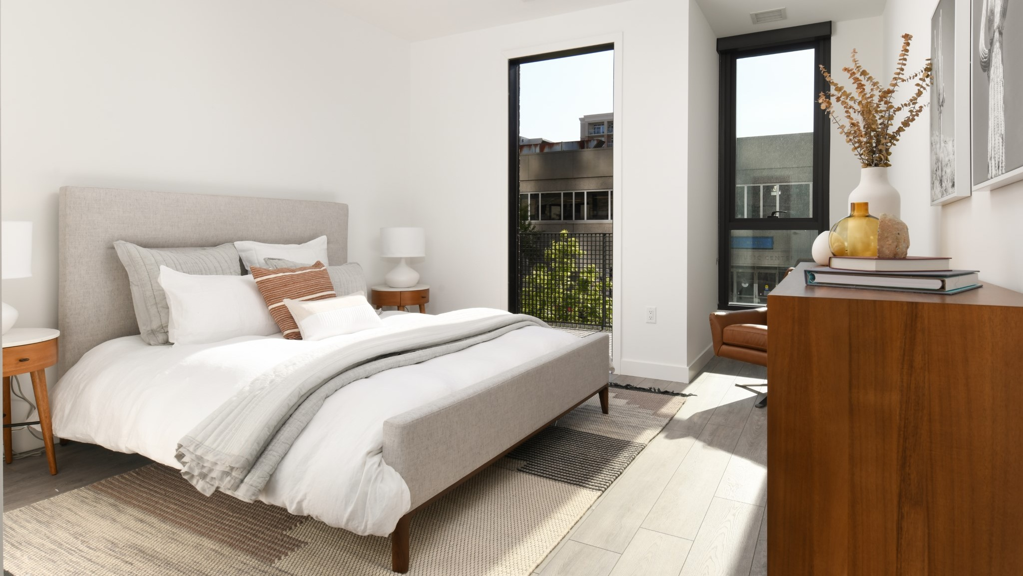 Bright and cozy apartment bedroom at Porte Apartments Chicago, featuring a comfortable bed, modern nightstands, and large windows