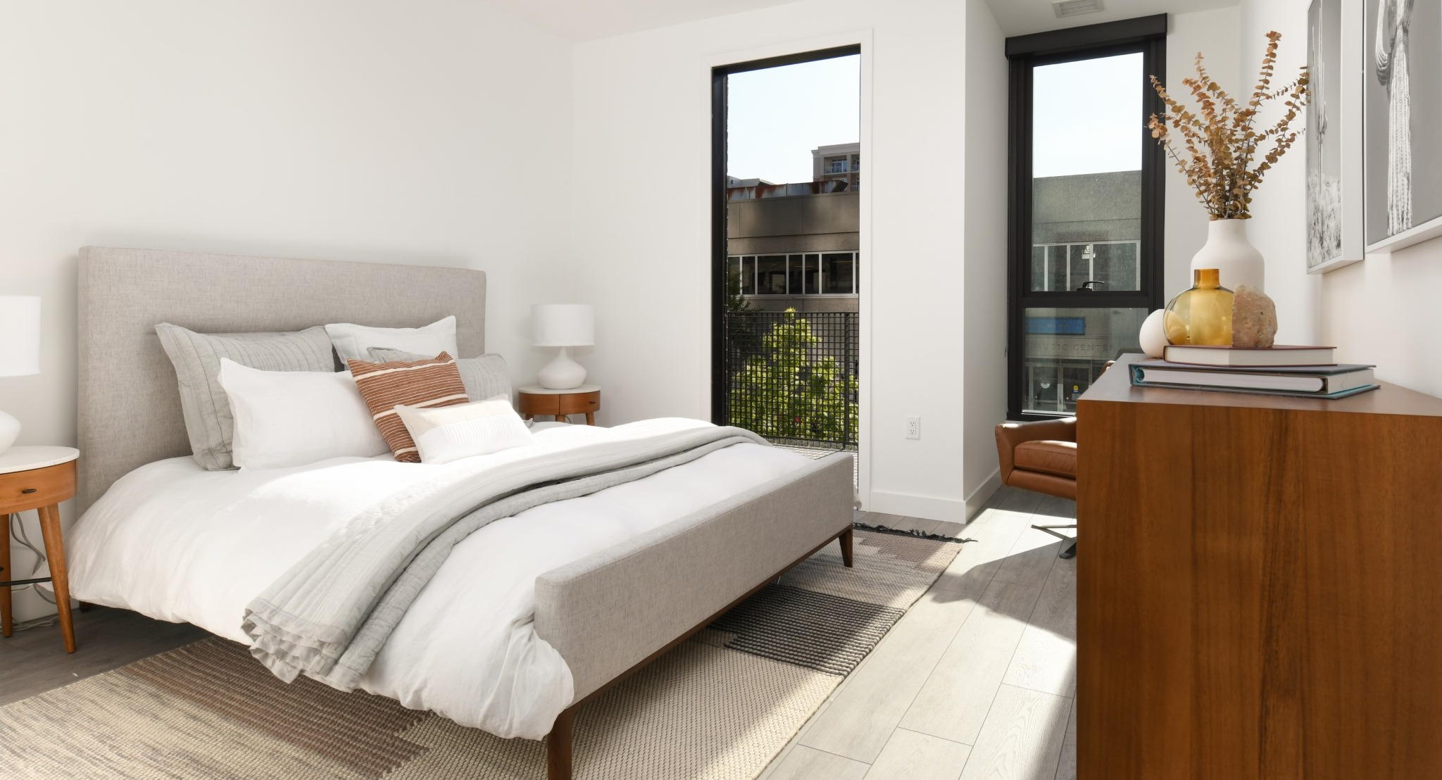 Bright and cozy apartment bedroom at Porte Apartments Chicago, featuring a comfortable bed, modern nightstands, and large windows