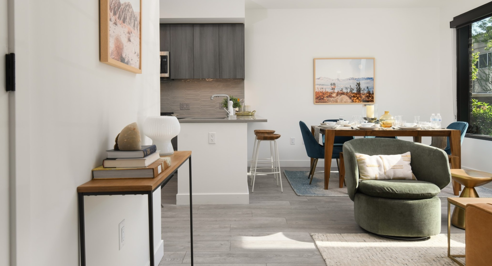 Panoramic view of the dining and living area at Porte Apartments Chicago, showcasing modern design, vibrant art, and ample space