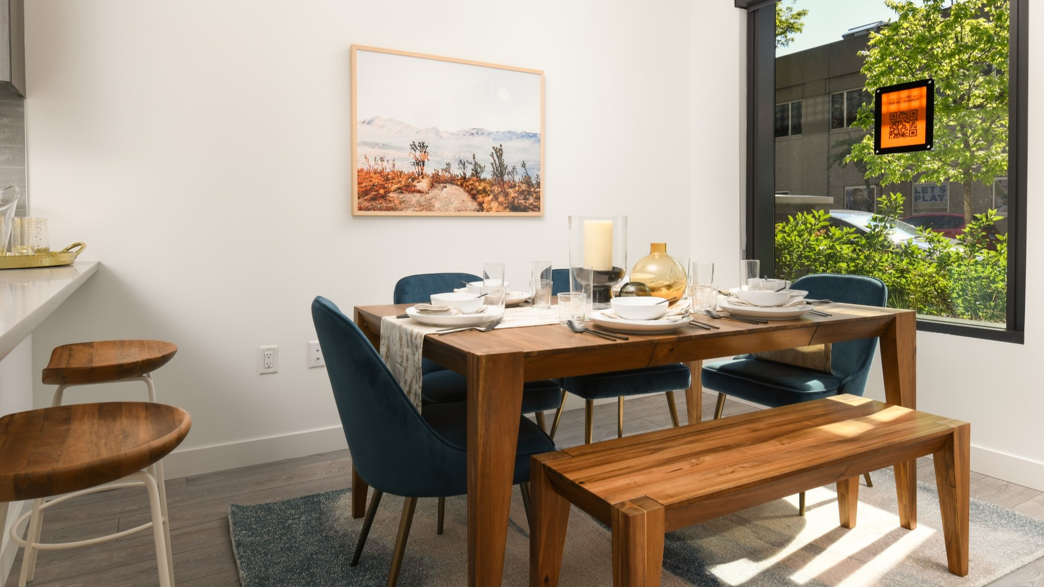 Elegant apartment dining area at Porte Apartments Chicago, featuring a wooden dining table, bench, and contemporary chairs with a window view