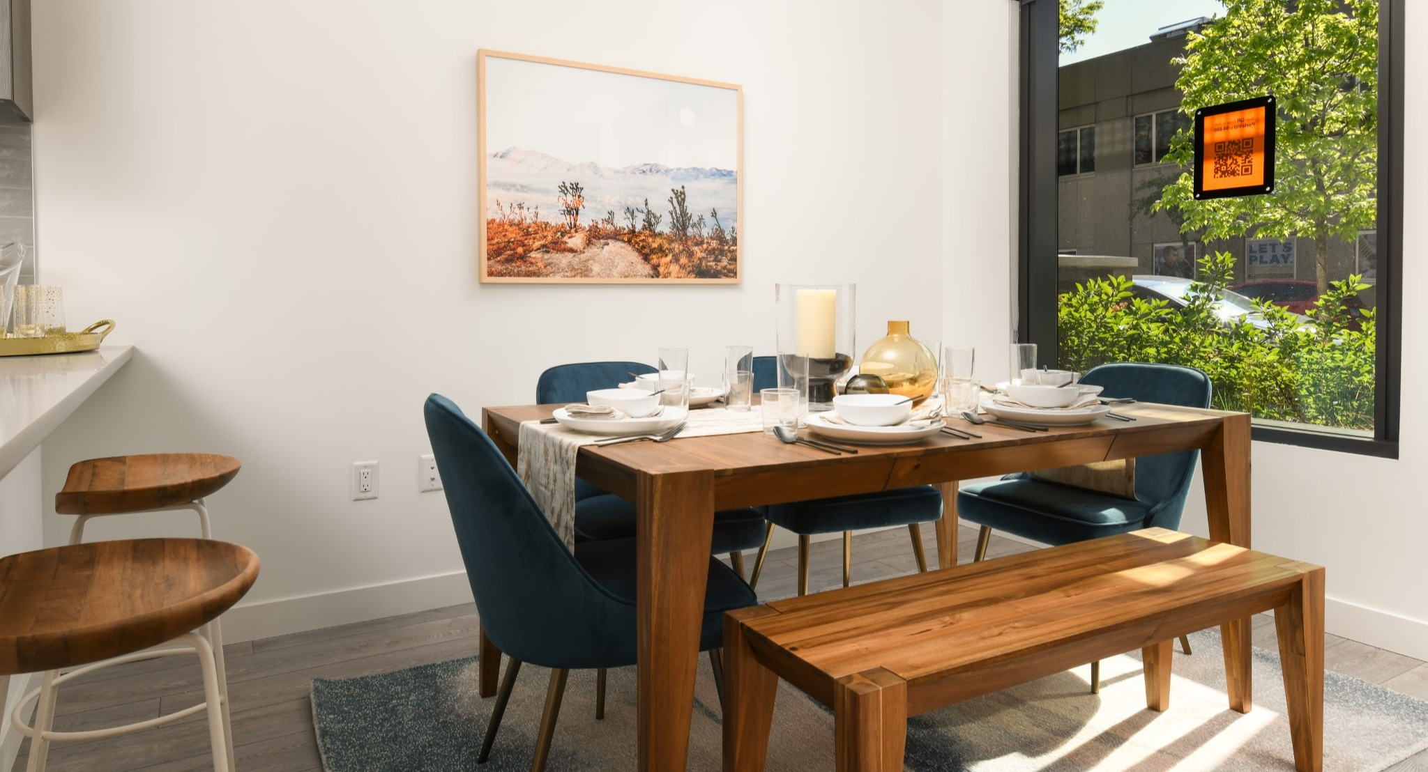 Elegant apartment dining area at Porte Apartments Chicago, featuring a wooden dining table, bench, and contemporary chairs with a window view