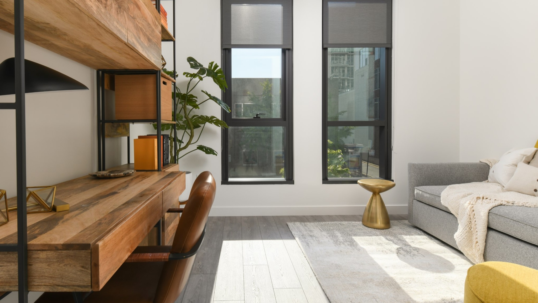 Dedicated home office space at Porte Apartments Chicago, featuring a stylish wooden desk, shelving, and large windows for natural light