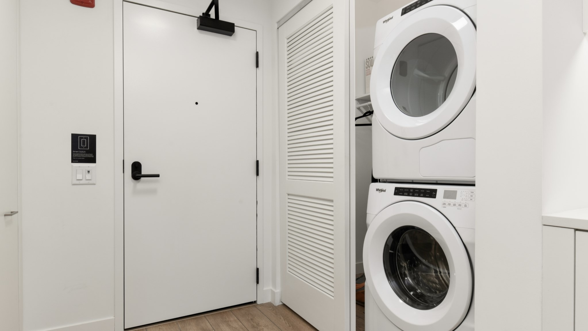 Convenient in-unit laundry area at Porte Apartments Chicago, featuring a stacked washer and dryer in a bright, clean space