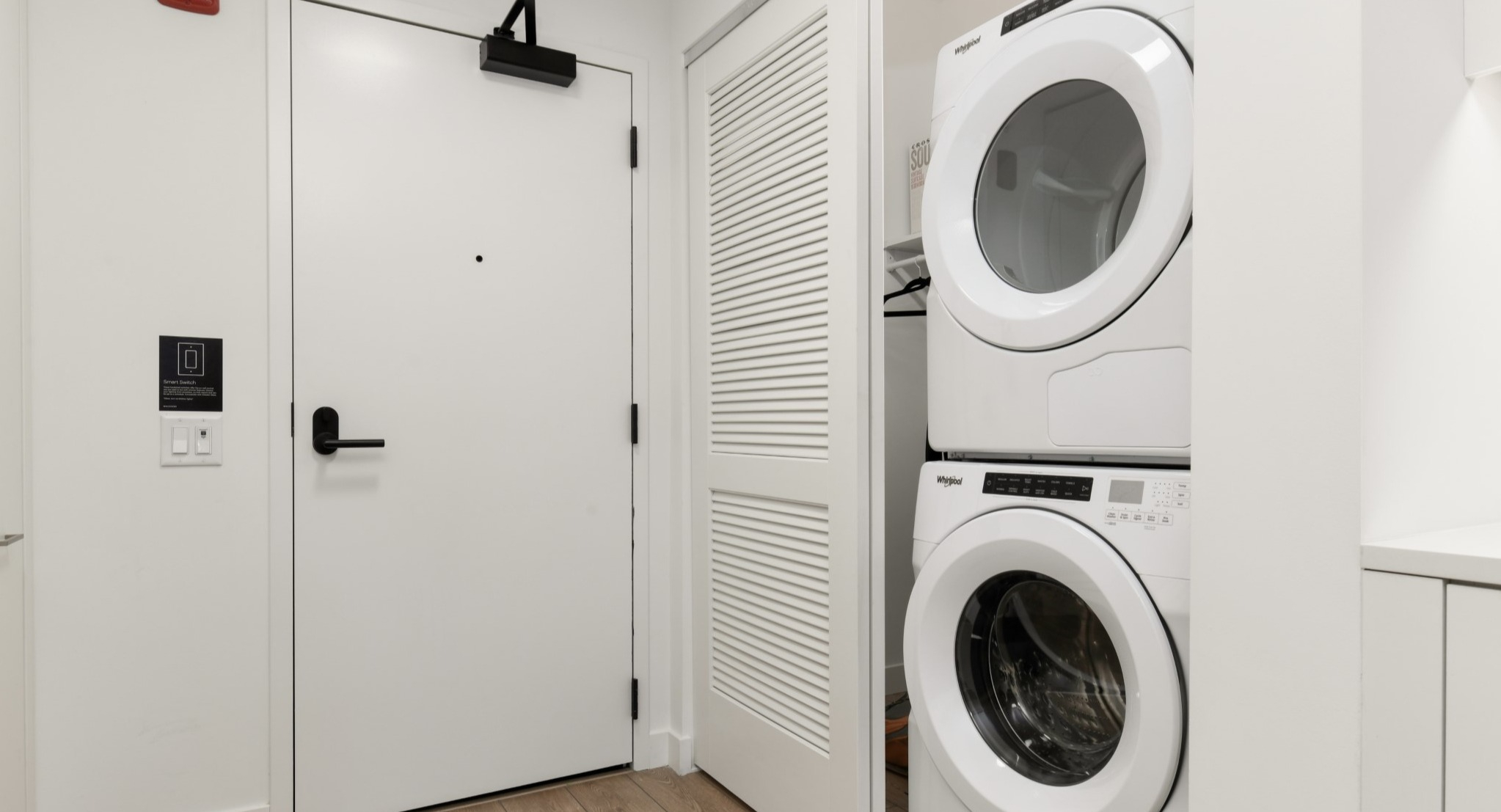 Convenient in-unit laundry area at Porte Apartments Chicago, featuring a stacked washer and dryer in a bright, clean space