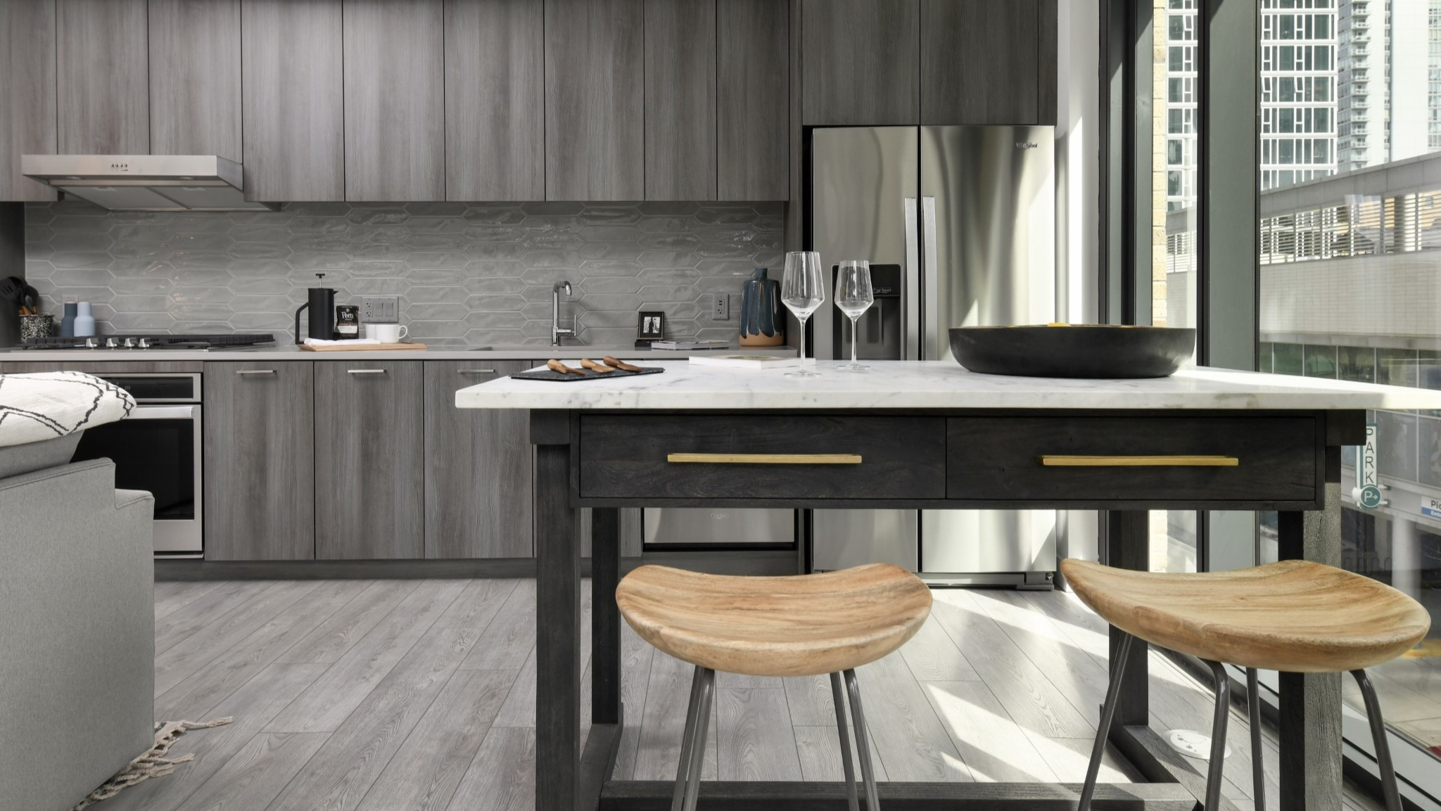 Modern apartment kitchen at Porte Apartments Chicago, featuring elegant wood-grain cabinets, stainless steel appliances, and an island