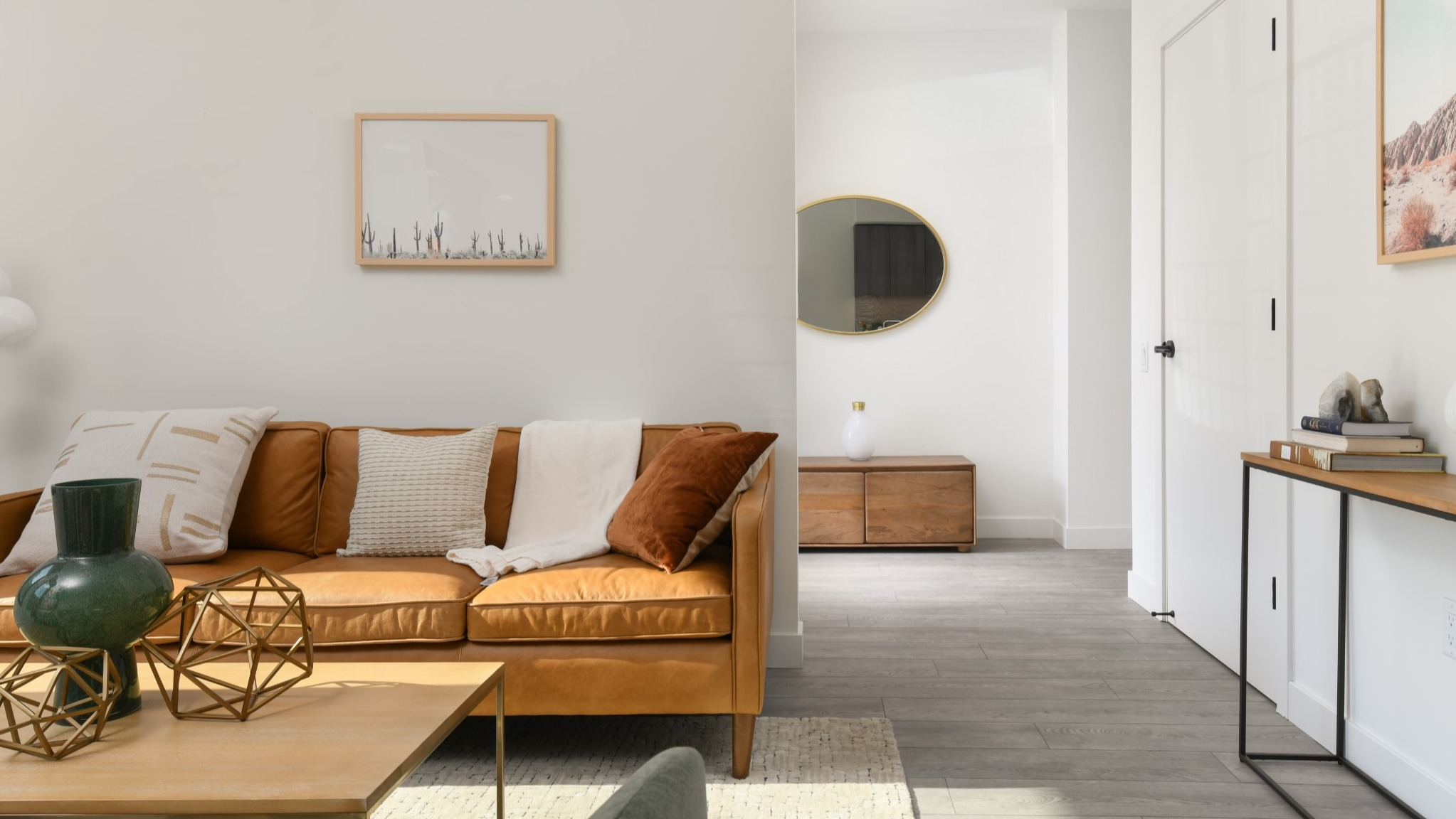 Inviting apartment living room at Porte Apartments Chicago, featuring a comfortable leather sofa, stylish decor, and warm natural light