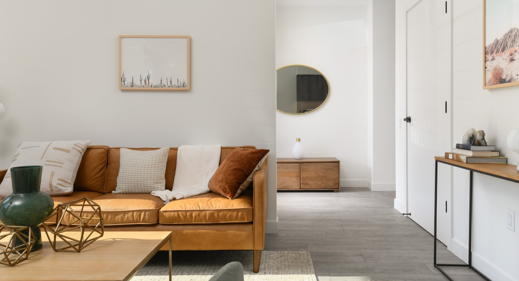 Inviting apartment living room at Porte Apartments Chicago, featuring a comfortable leather sofa, stylish decor, and warm natural light