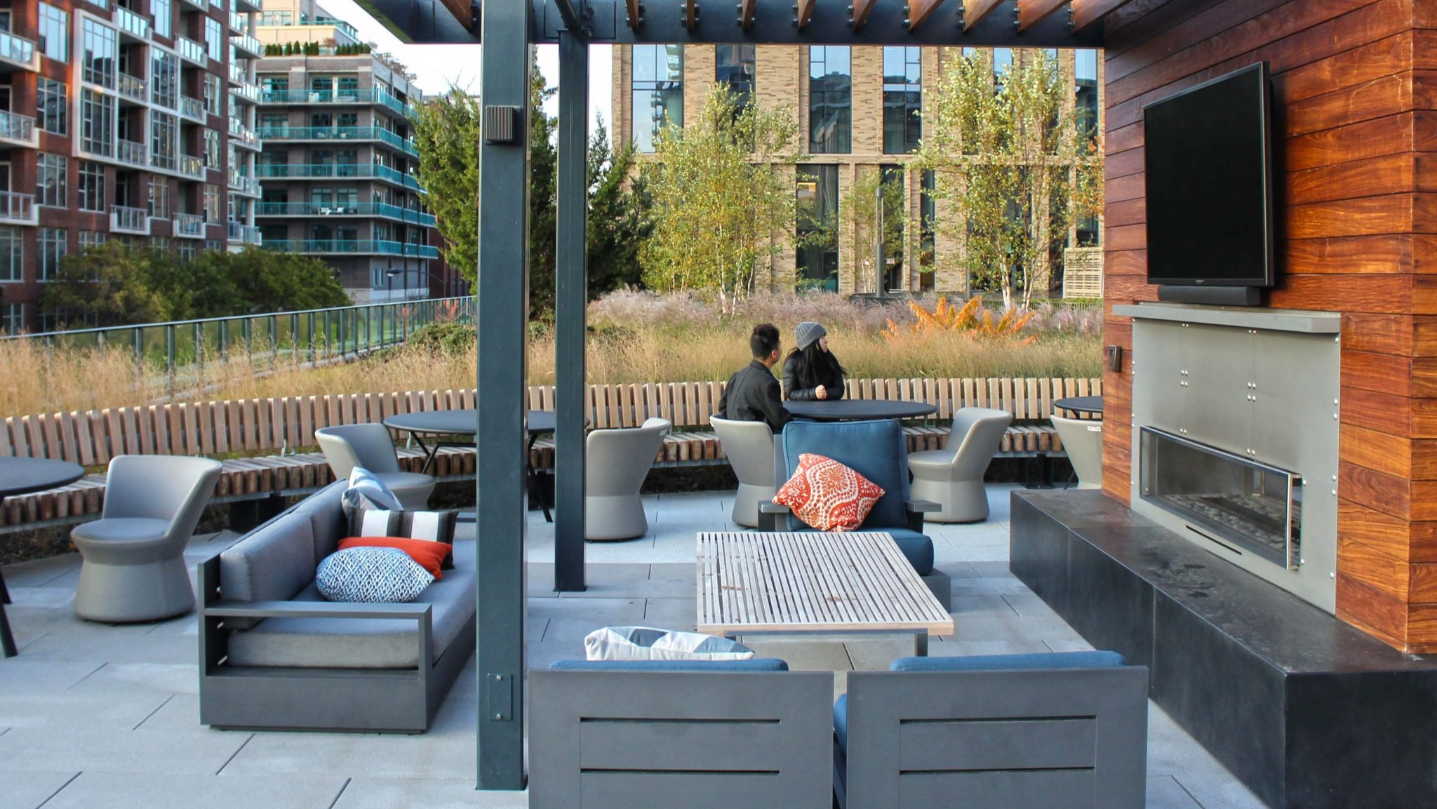 Inviting rooftop lounge at Porte Apartments Chicago, featuring an outdoor fireplace, seating areas, and a modern aesthetic