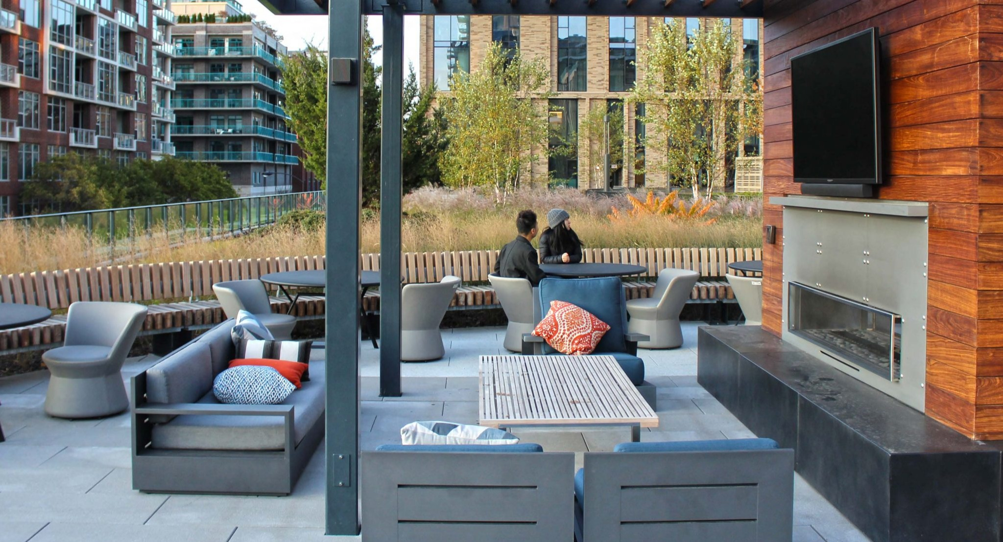 Inviting rooftop lounge at Porte Apartments Chicago, featuring an outdoor fireplace, seating areas, and a modern aesthetic