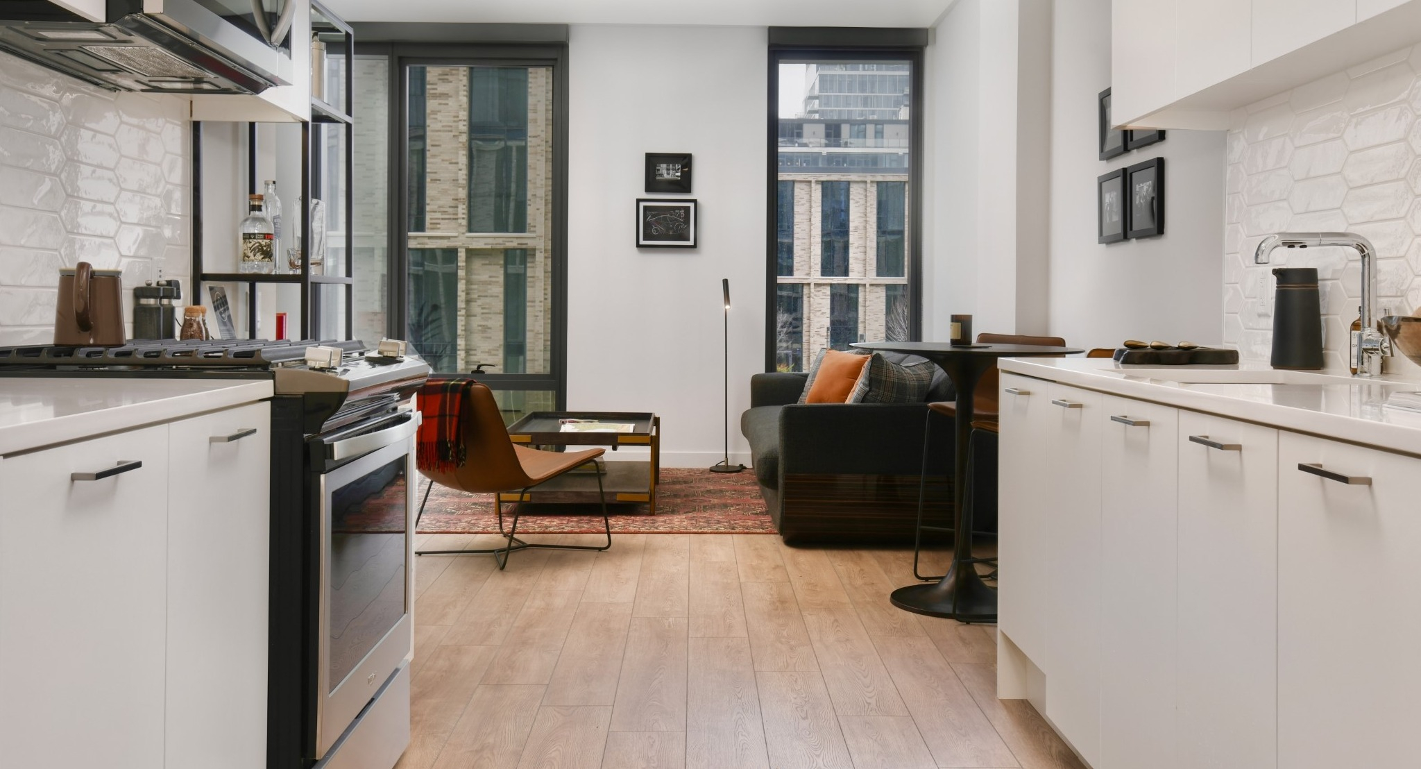 Bright apartment kitchen at Porte Apartments Chicago, featuring white cabinetry, subway tile backsplash, and stainless steel appliances
