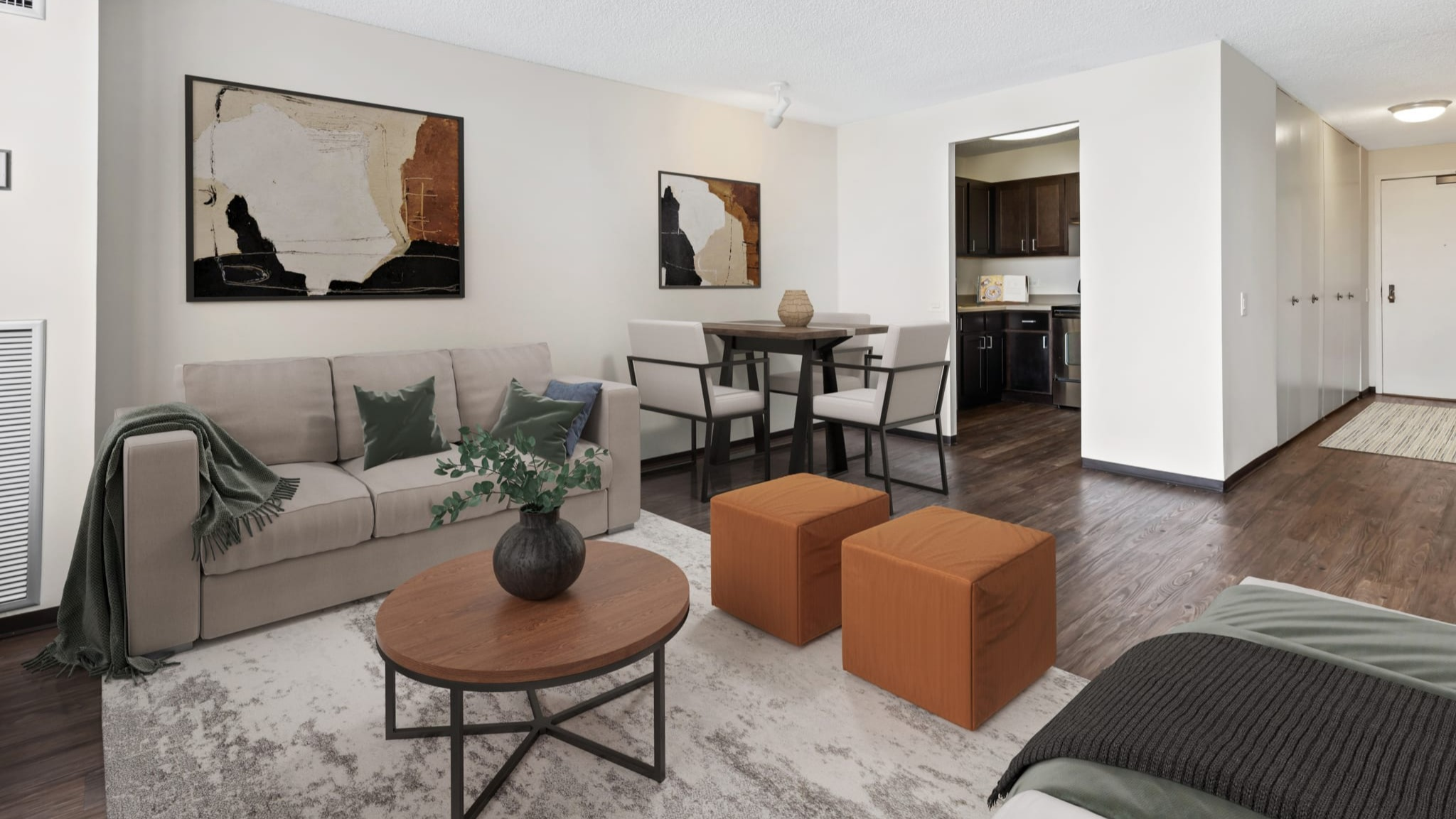 Open-concept living room with dining area and sightline to the kitchen, wood-style floors, and neutral decor at Presidential Towers Chicago