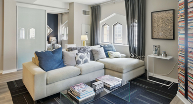 Cozy apartment living room at Randolph Tower City Apartments in Chicago, featuring a comfortable sectional sofa and unique window designs