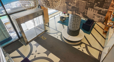 Grand lobby entrance at Randolph Tower City Apartments in Chicago, featuring stunning chandeliers, unique flooring, and city-themed wall art