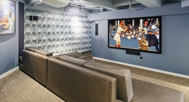 Private media room at Randolph Tower City Apartments in Chicago, featuring comfortable tiered seating and a large projection screen