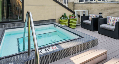 Luxurious rooftop hot tub area at Randolph Tower City Apartments in Chicago, featuring comfortable seating and city views