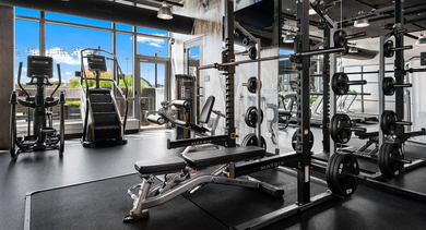 Comprehensive gym at Reside on Green Street in Chicago, featuring weight training equipment, free weights, and large mirrors