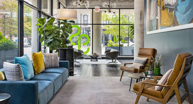 Inviting lobby lounge with colorful sofas, unique chairs, and vibrant wall art, creating a lively atmosphere at Reside on Green Street in Chicago
