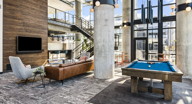 Vibrant resident lounge at Reside on Green Street in Chicago, featuring an industrial chic design, a pool table, and comfortable seating