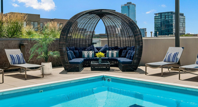 Stylish rooftop lounge area with a shaded cabana and comfortable seating next to the swimming pool at Reside on Green Street in Chicago