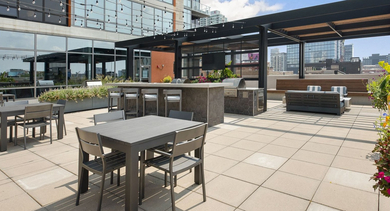 Spacious rooftop terrace with grilling stations, bar seating, and outdoor dining tables, perfect for entertaining at Reside on Green Street in Chicago