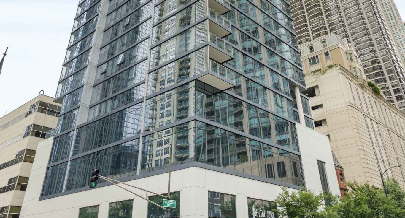Modern high-rise apartment building exterior with glass facades and ground-level retail, typical of downtown Chicago architecture at Residences at 8 East Huron