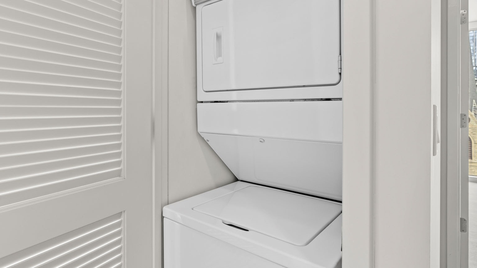 Convenient in-unit stacked washer and dryer unit discreetly placed in a closet at Residences at 8 East Huron in Chicago