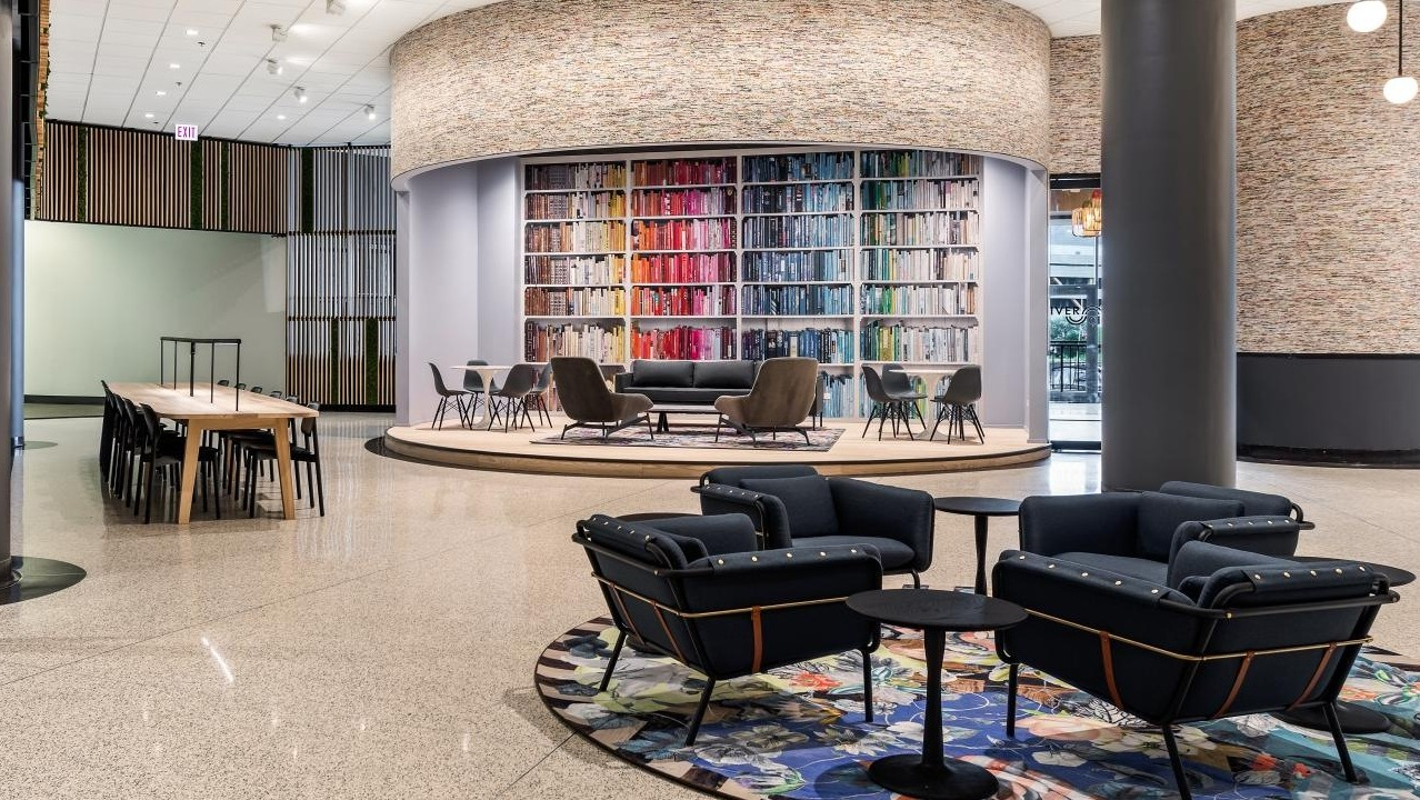 Expansive lobby lounge with modern seating, vibrant rug, and unique architectural features, ideal for socializing at River City Apartments in Chicago