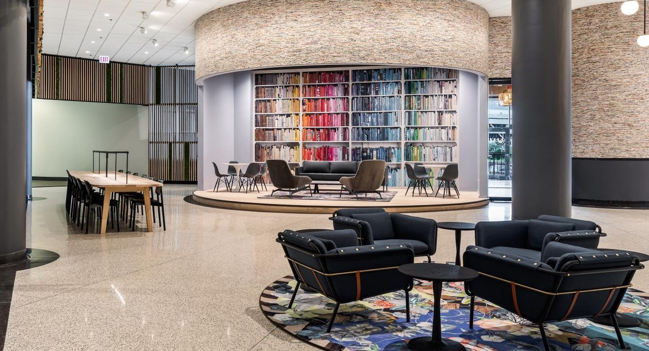 Expansive lobby lounge with modern seating, vibrant rug, and unique architectural features, ideal for socializing at River City Apartments in Chicago