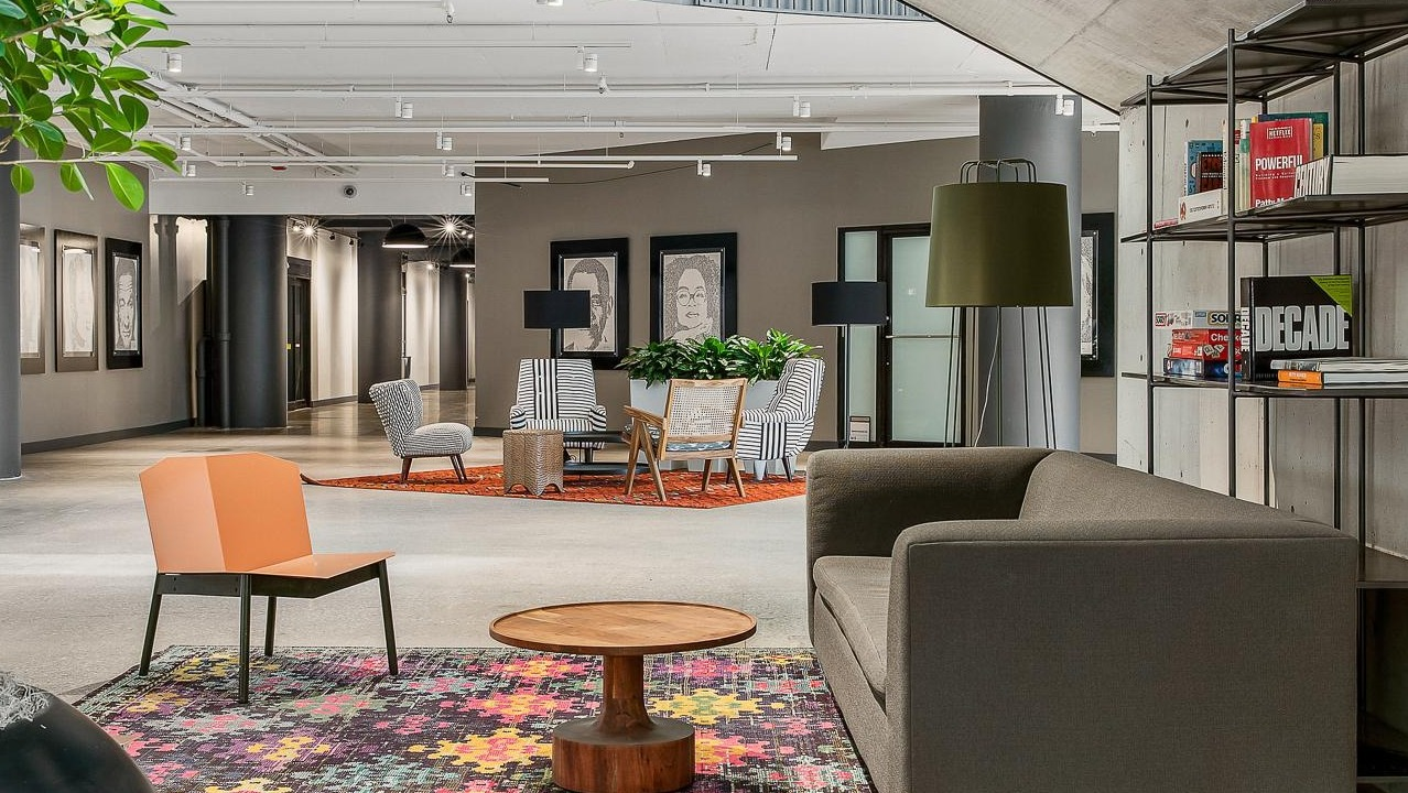 Contemporary resident lounge with abstract art, varied seating, and industrial-chic elements, perfect for unwinding at River City Apartments in Chicago