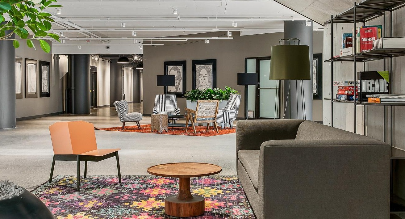 Contemporary resident lounge with abstract art, varied seating, and industrial-chic elements, perfect for unwinding at River City Apartments in Chicago