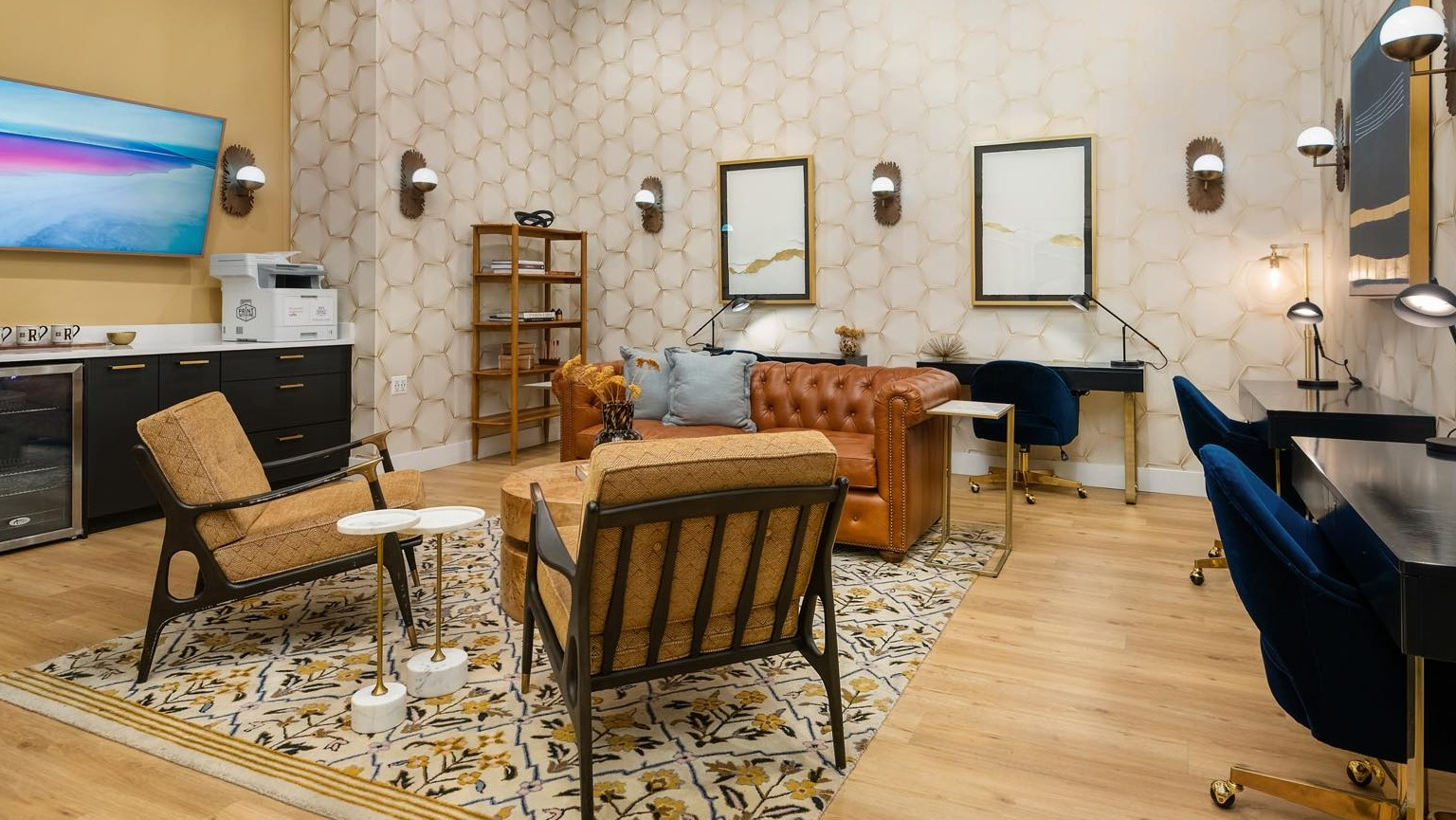 Elegant business center and lounge with individual desks, comfortable seating, and a fully stocked bar area at Roosevelt Collection Lofts