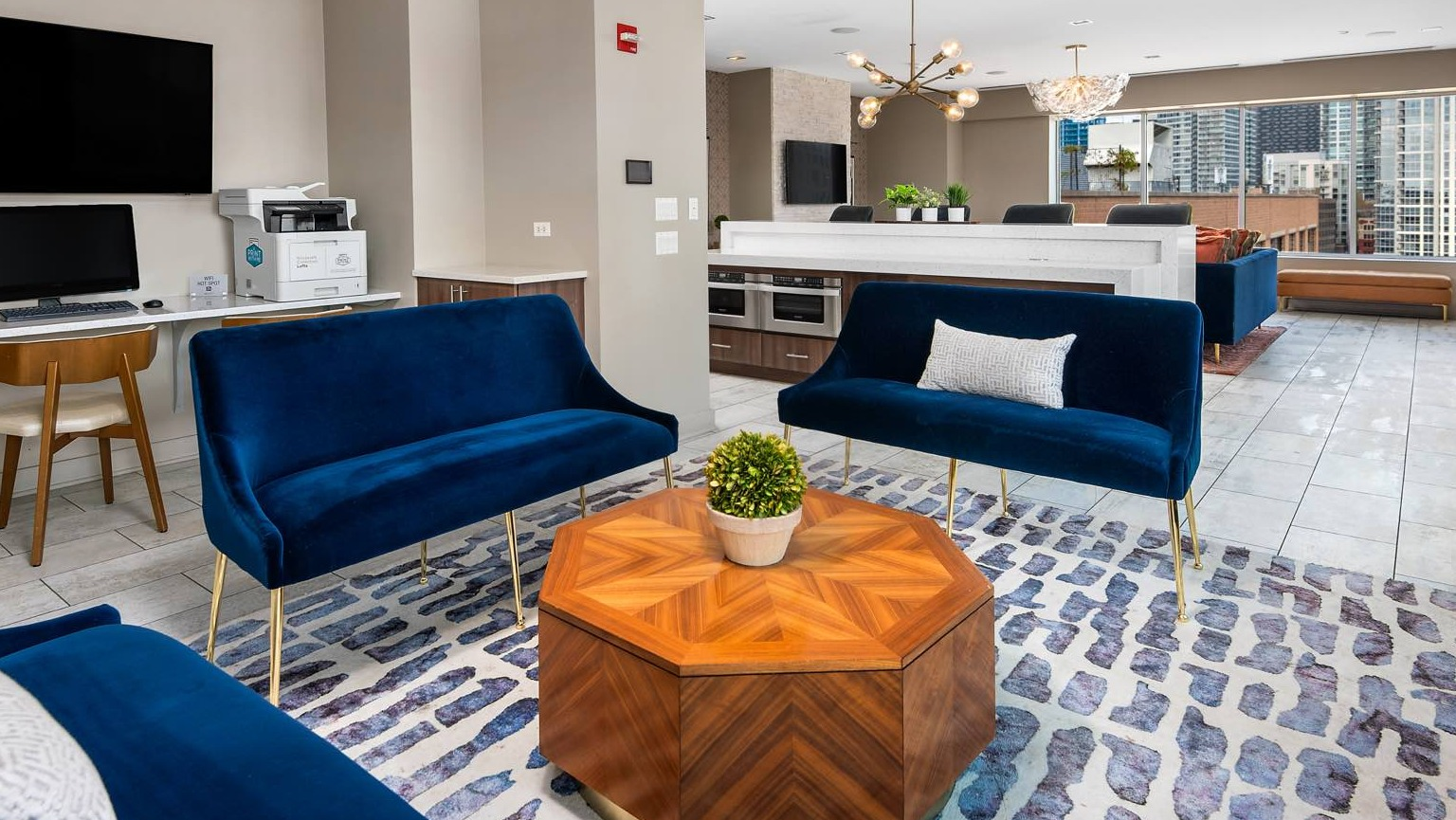 Versatile communal lounge area with comfortable seating, a shared workspace, and modern lighting at Roosevelt Collection Lofts