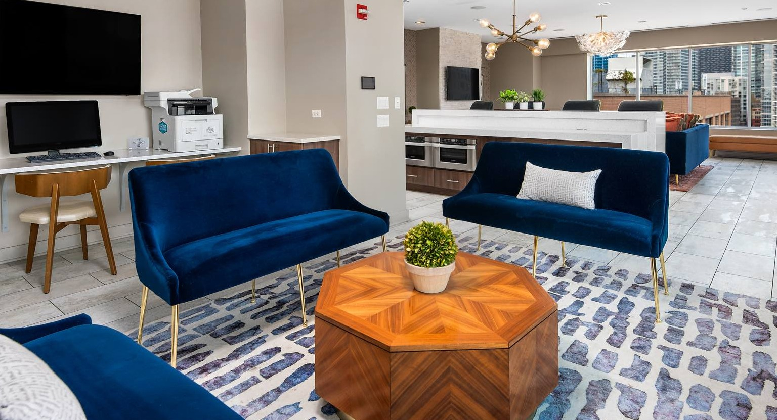 Versatile communal lounge area with comfortable seating, a shared workspace, and modern lighting at Roosevelt Collection Lofts