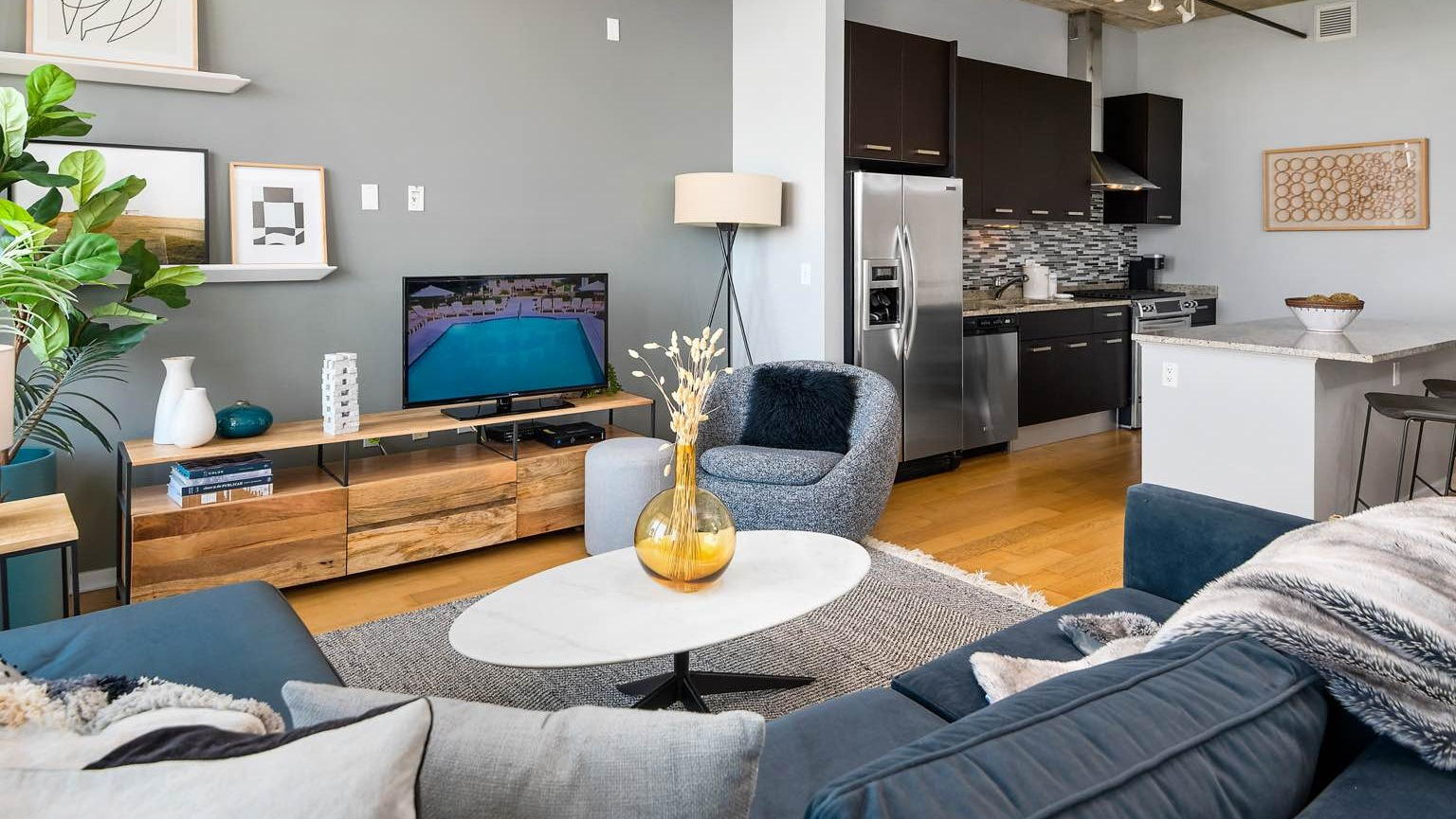 Cozy living room at Roosevelt Collection Lofts in Chicago, featuring a large sectional sofa, entertainment console, and contemporary decor