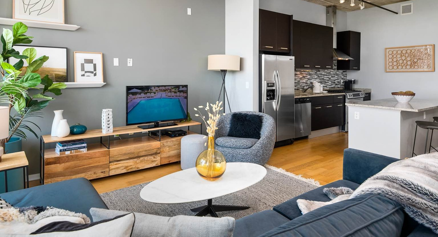 Cozy living room at Roosevelt Collection Lofts in Chicago, featuring a large sectional sofa, entertainment console, and contemporary decor