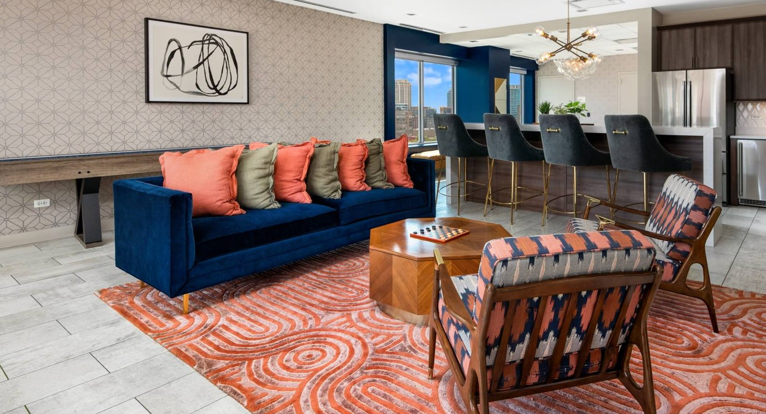 Lively resident lounge with a bar area, comfortable sofas, a shuffleboard table, and vibrant decor at Roosevelt Collection Lofts