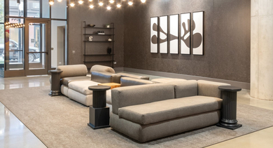 Stylish lobby lounge at Sage West Loop Apartments in Chicago, featuring modern sofas, artistic lighting, and contemporary decor