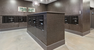 Modern and well-lit mailroom at Sage West Loop Apartments in Chicago, featuring individual mailboxes and decorative lighting