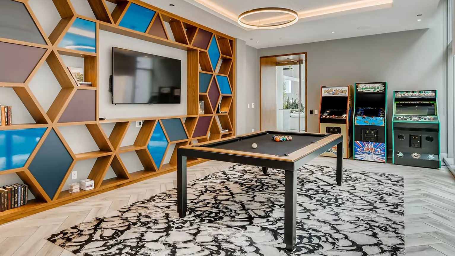 Lively arcade and game room at Sentral Michigan Avenue in Chicago, featuring a pool table, classic arcade games, and modern shelving