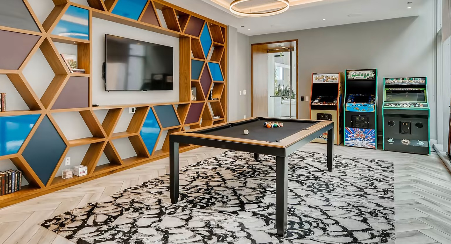 Lively arcade and game room at Sentral Michigan Avenue in Chicago, featuring a pool table, classic arcade games, and modern shelving