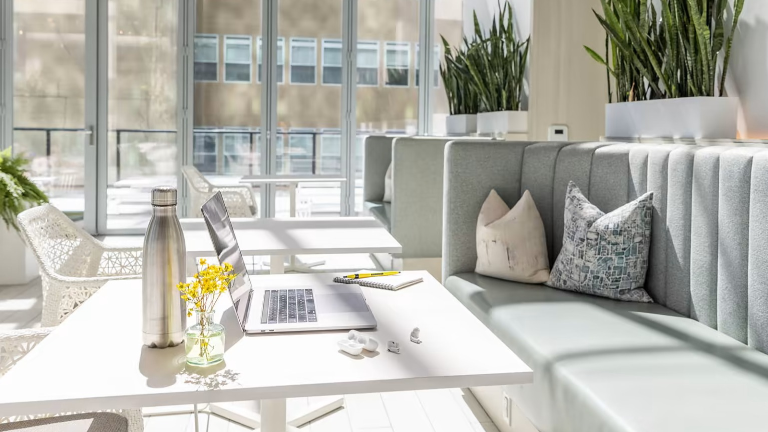 Bright co-working space at Sentral Michigan Avenue in Chicago, featuring comfortable seating, individual tables, and natural light
