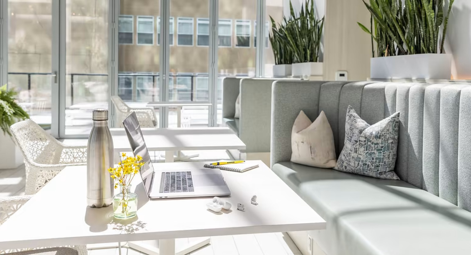 Bright co-working space at Sentral Michigan Avenue in Chicago, featuring comfortable seating, individual tables, and natural light