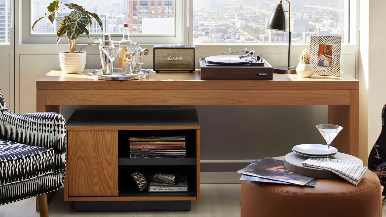 Chic entertainment area at Sentral Michigan Avenue in Chicago, featuring an armchair, record player, and a guitar, with city views