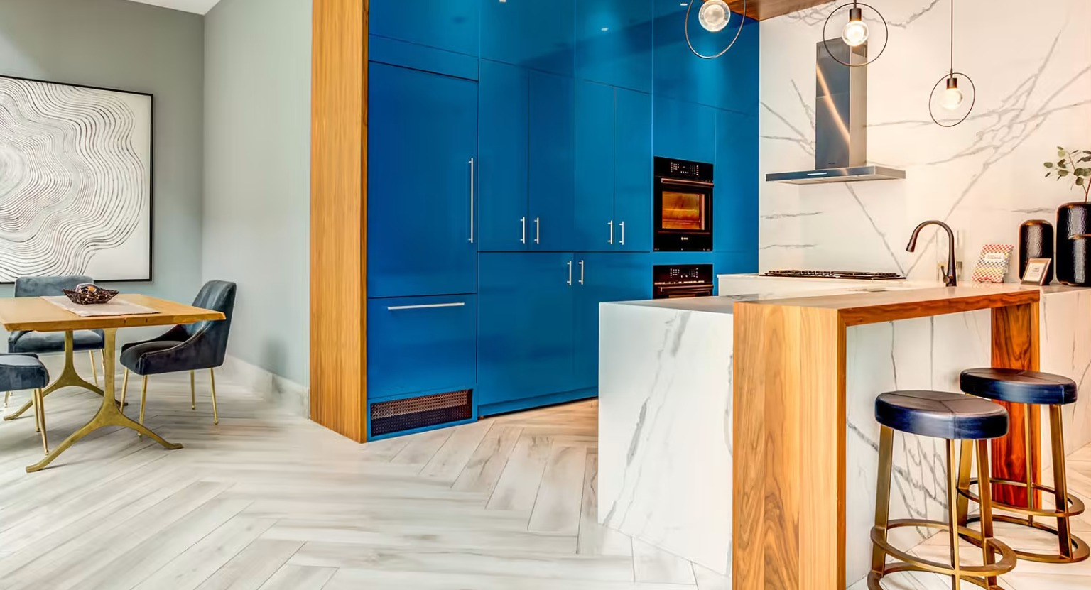 Stylish gourmet kitchen and dining area at Sentral Michigan Avenue in Chicago, featuring bold blue cabinetry, a marble island, and modern dining furniture
