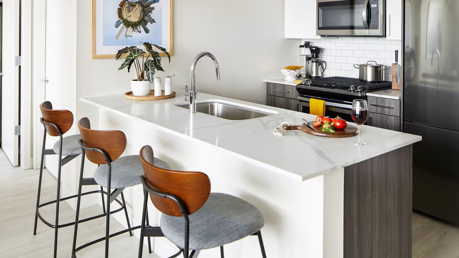 Stylish apartment kitchen at Sentral Michigan Avenue in Chicago, featuring a large island with bar seating, and modern appliances