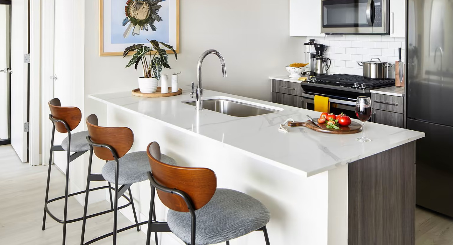 Stylish apartment kitchen at Sentral Michigan Avenue in Chicago, featuring a large island with bar seating, and modern appliances