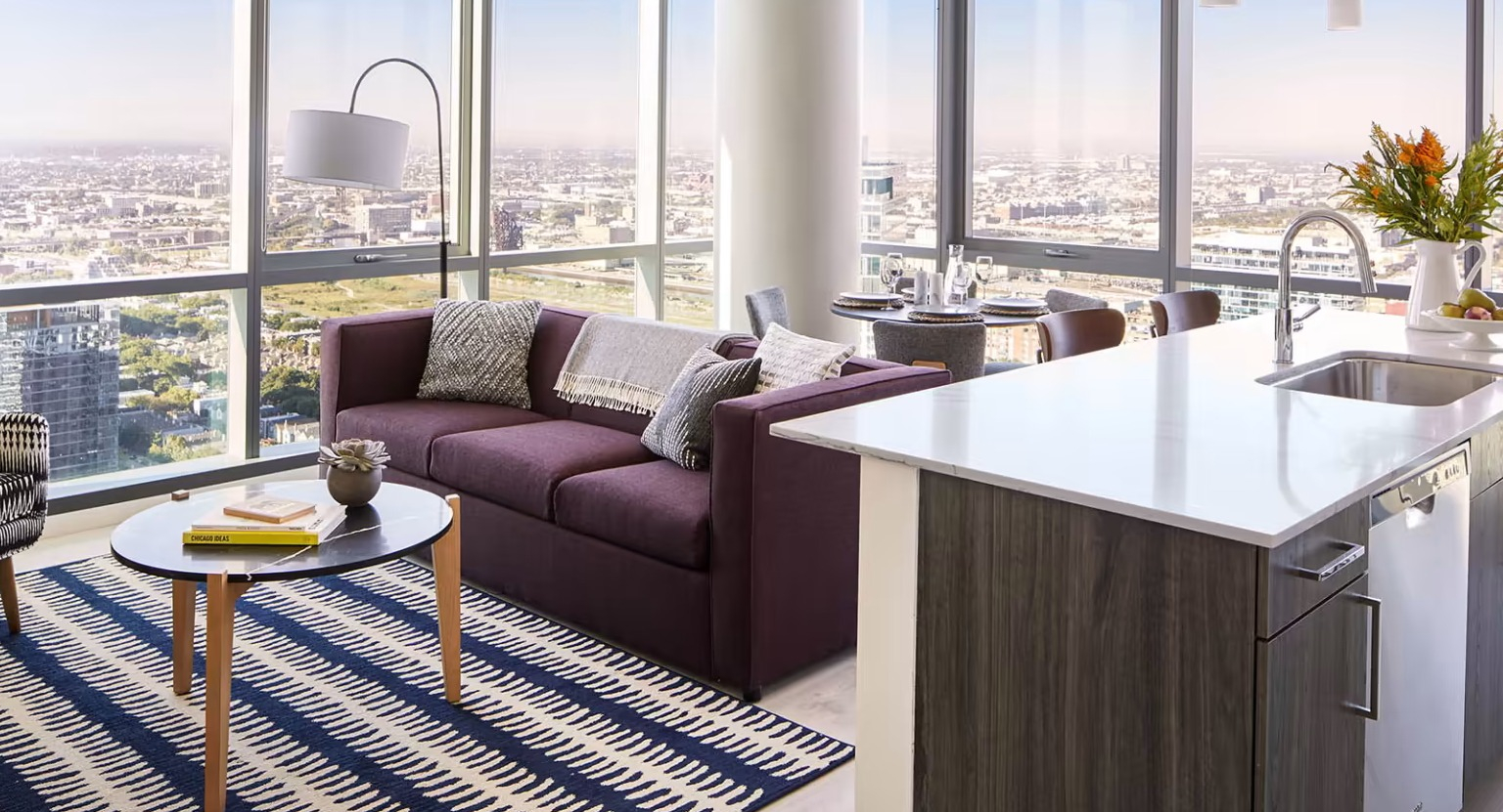 Modern apartment living room at Sentral Michigan Avenue in Chicago, featuring a comfortable sofa, stylish rug, and expansive city views