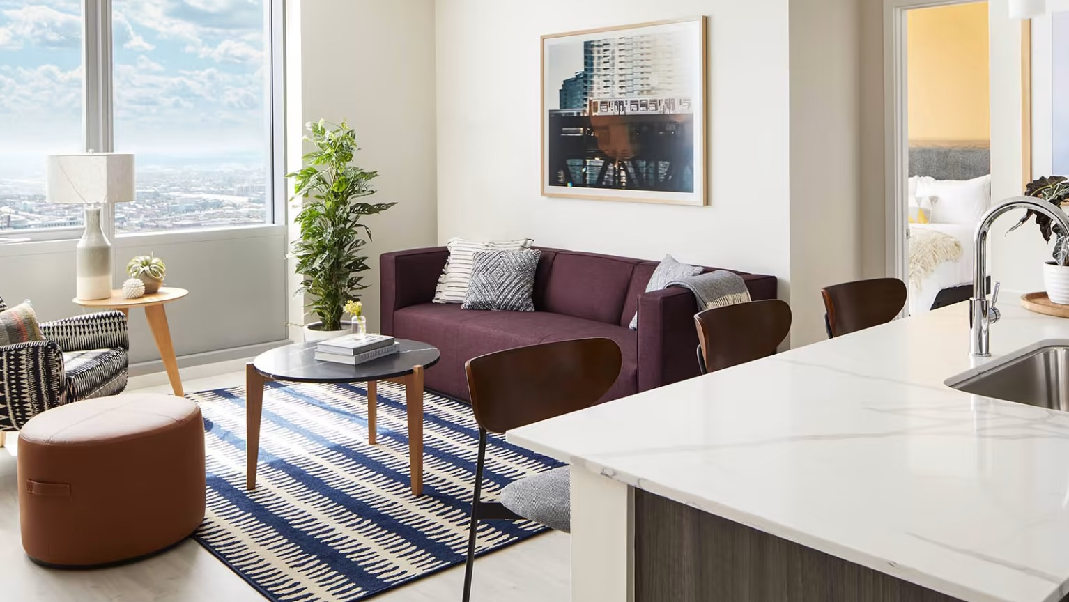 Open-concept apartment at Sentral Michigan Avenue in Chicago, featuring a modern kitchen island, comfortable living area, and large windows